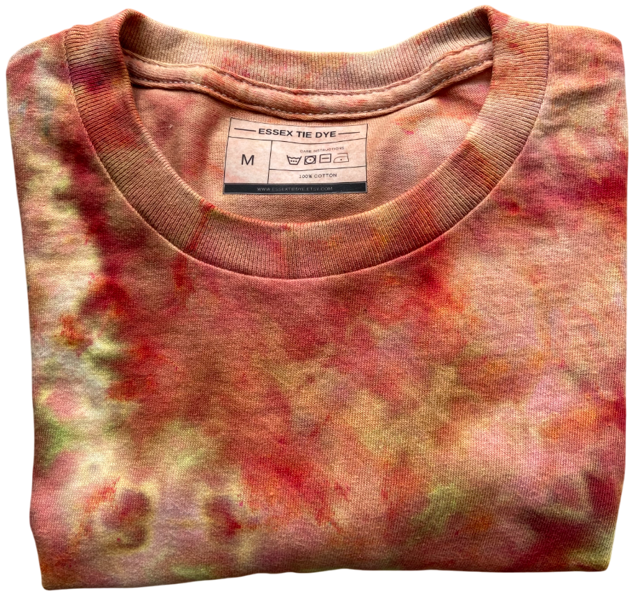 Folded tie-dye shirt with a visible brand label on a white background