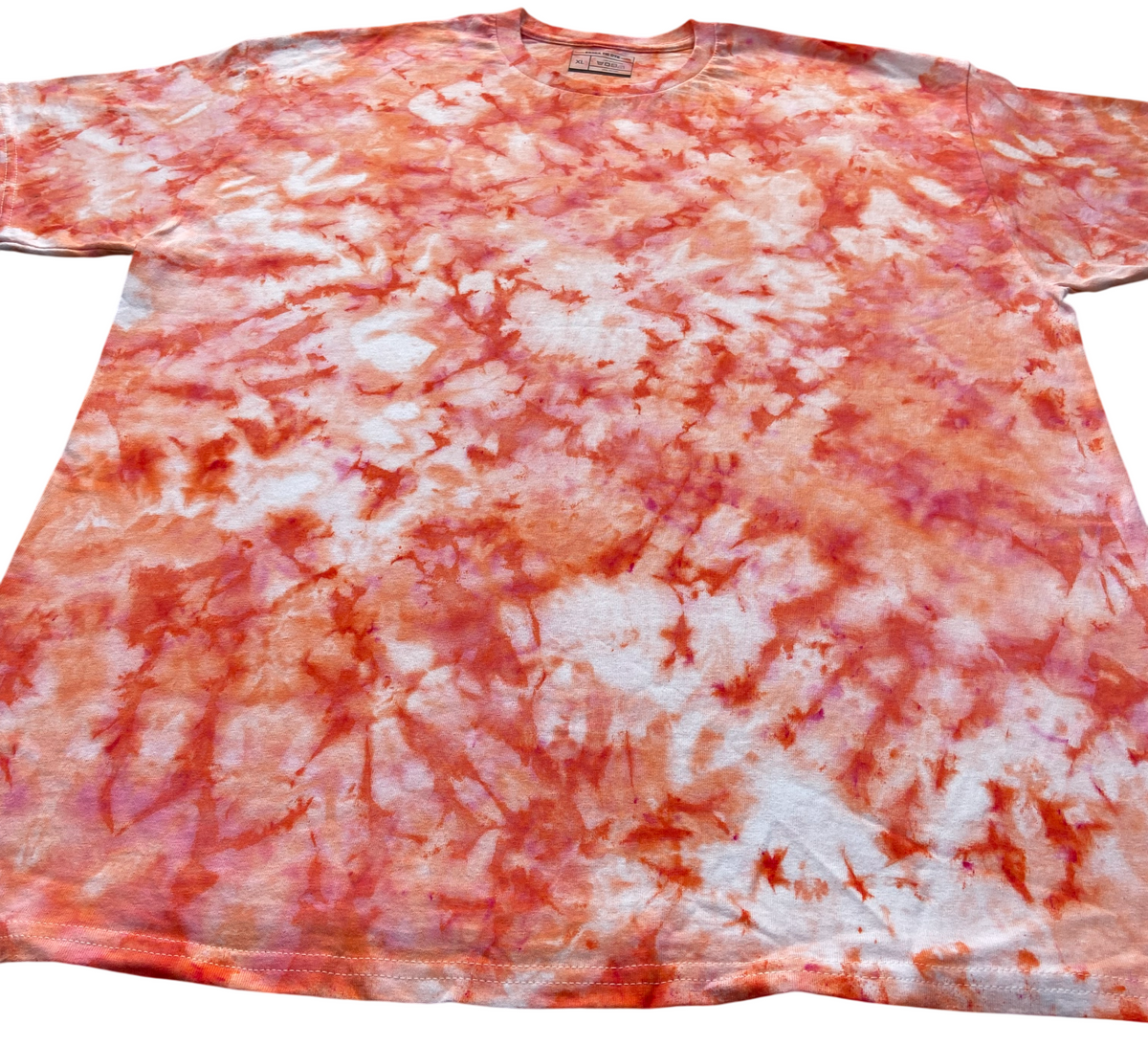 Angled view of the Peach Ice Scrunch tie-dye T-shirt featuring peach, coral pink, soft blush and white marbled patterns.