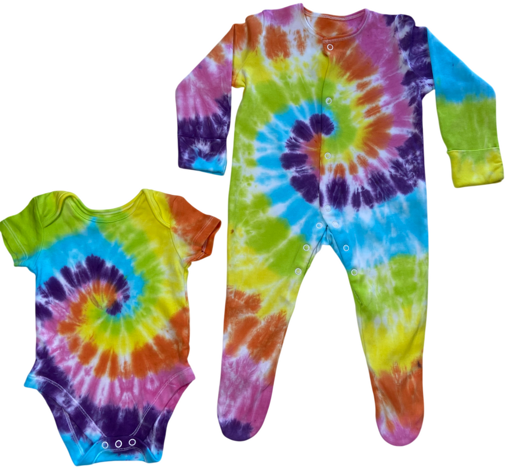 Rainbow spiral tie dye baby vest and sleepsuit in bright blue, green, yellow, orange and purple, hand dyed in the UK by Essex Tie Dye.