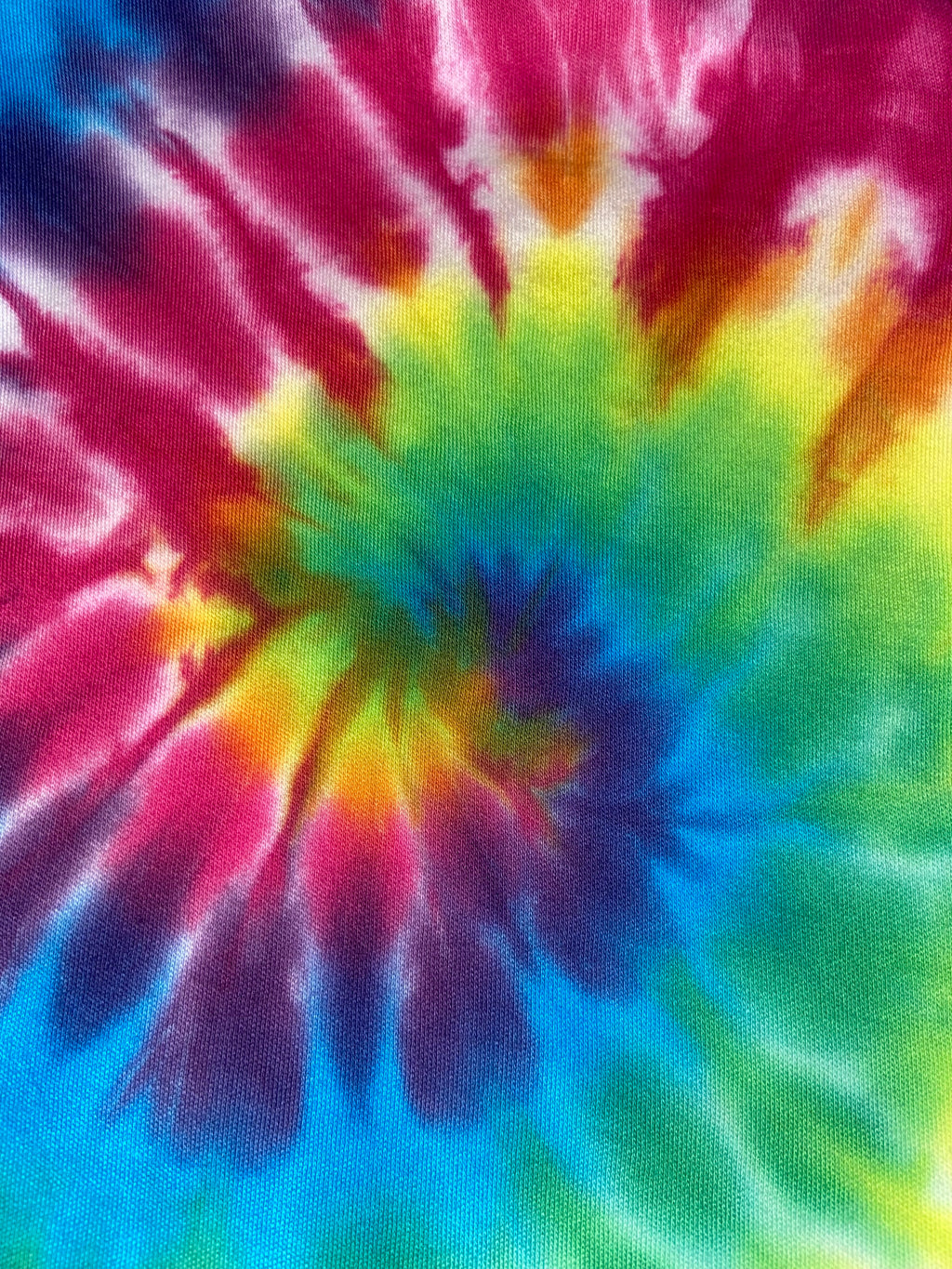 Close-up of a tie-dye fabric with vibrant colors.