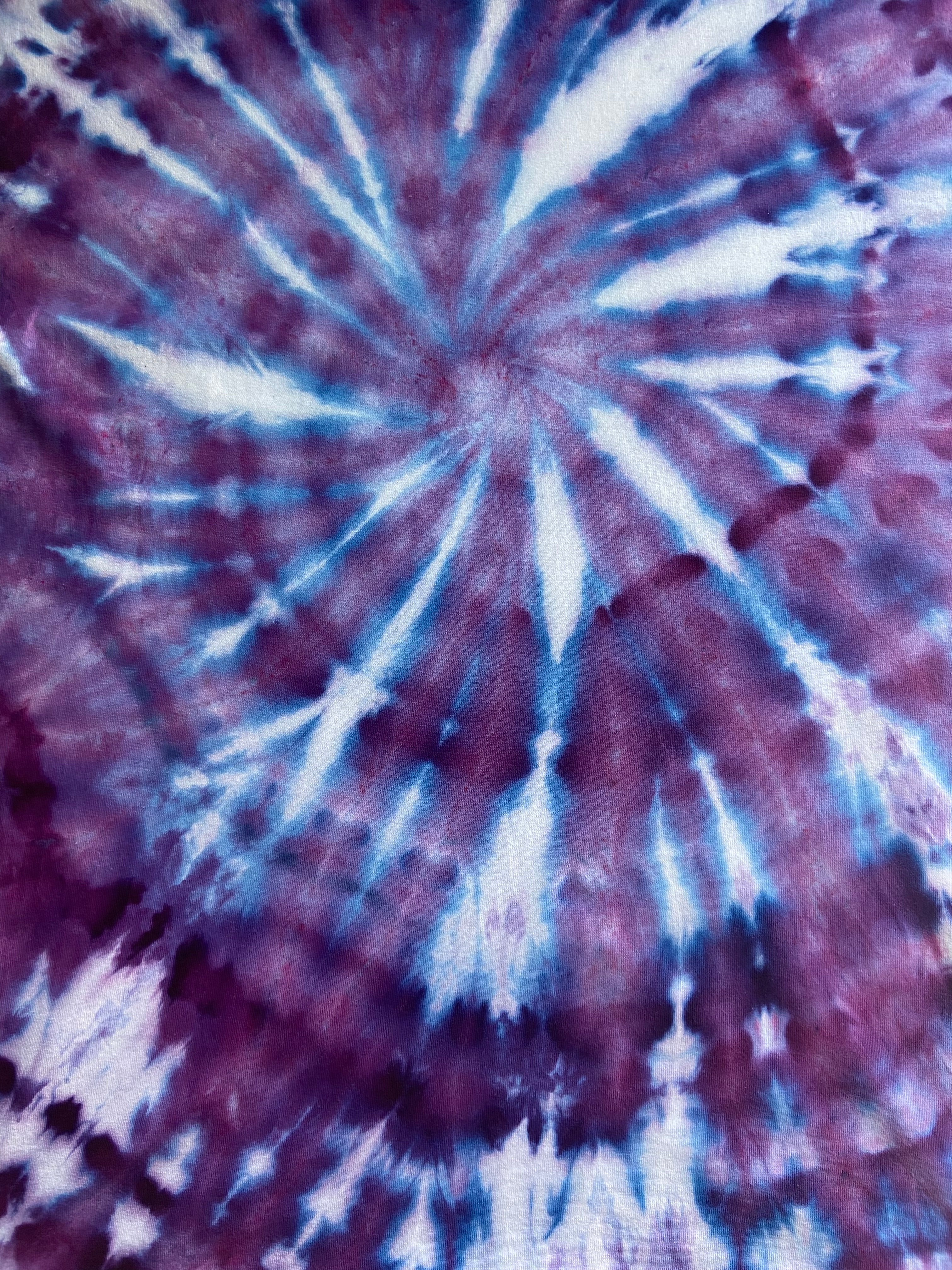 Close-up of tie-dye fabric with purple and white patterns