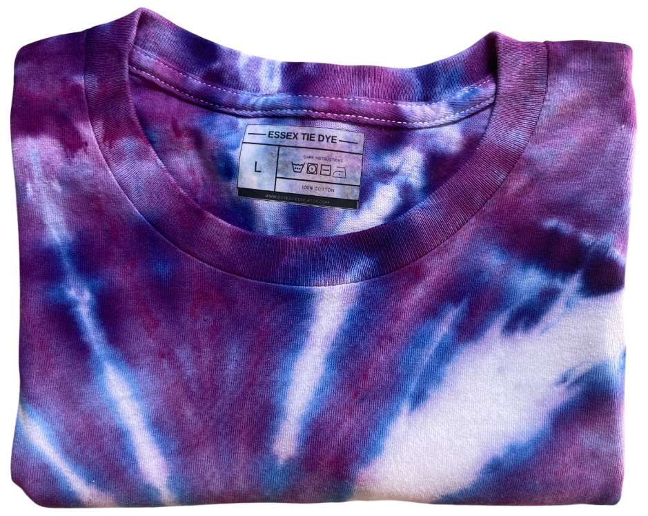 Folded tie-dye shirt with a visible label on a white background