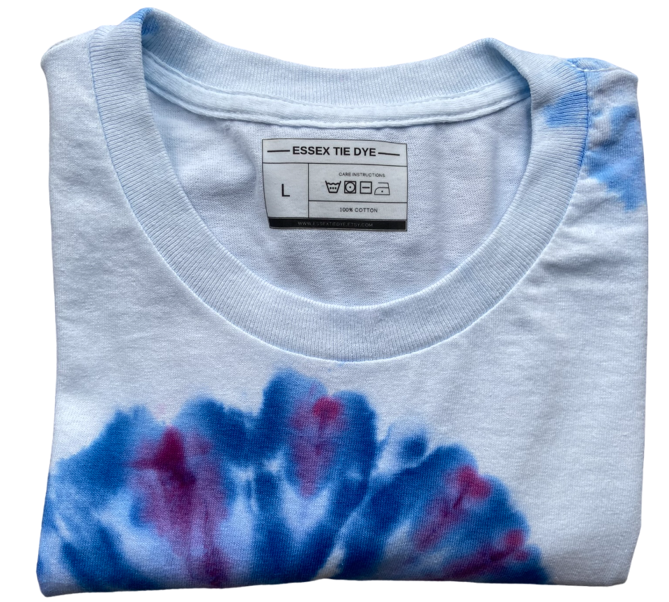 Folded tie-dye shirt with a visible label on a white background