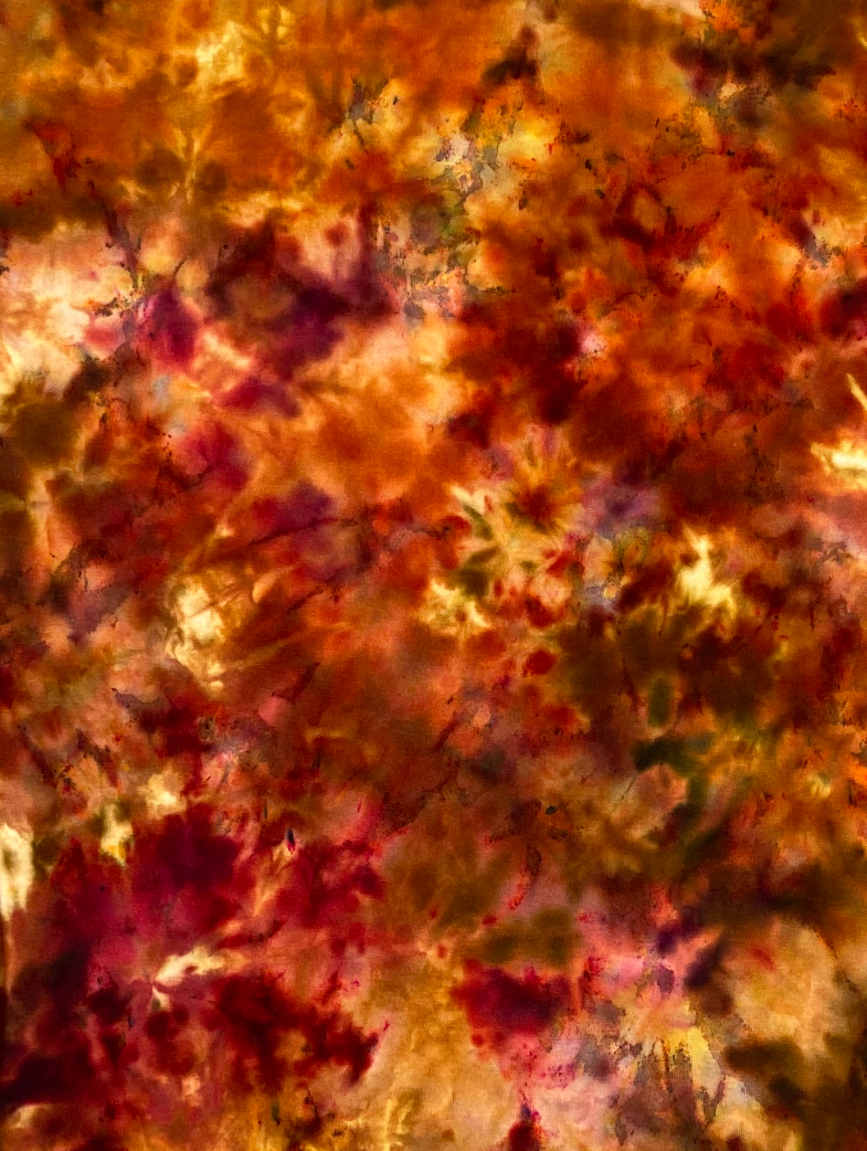 Close-up of the Firestone Ice Scrunch tie-dye sweatshirt showing burnt orange, amber, golden yellow and deep brown tie-dye detail.