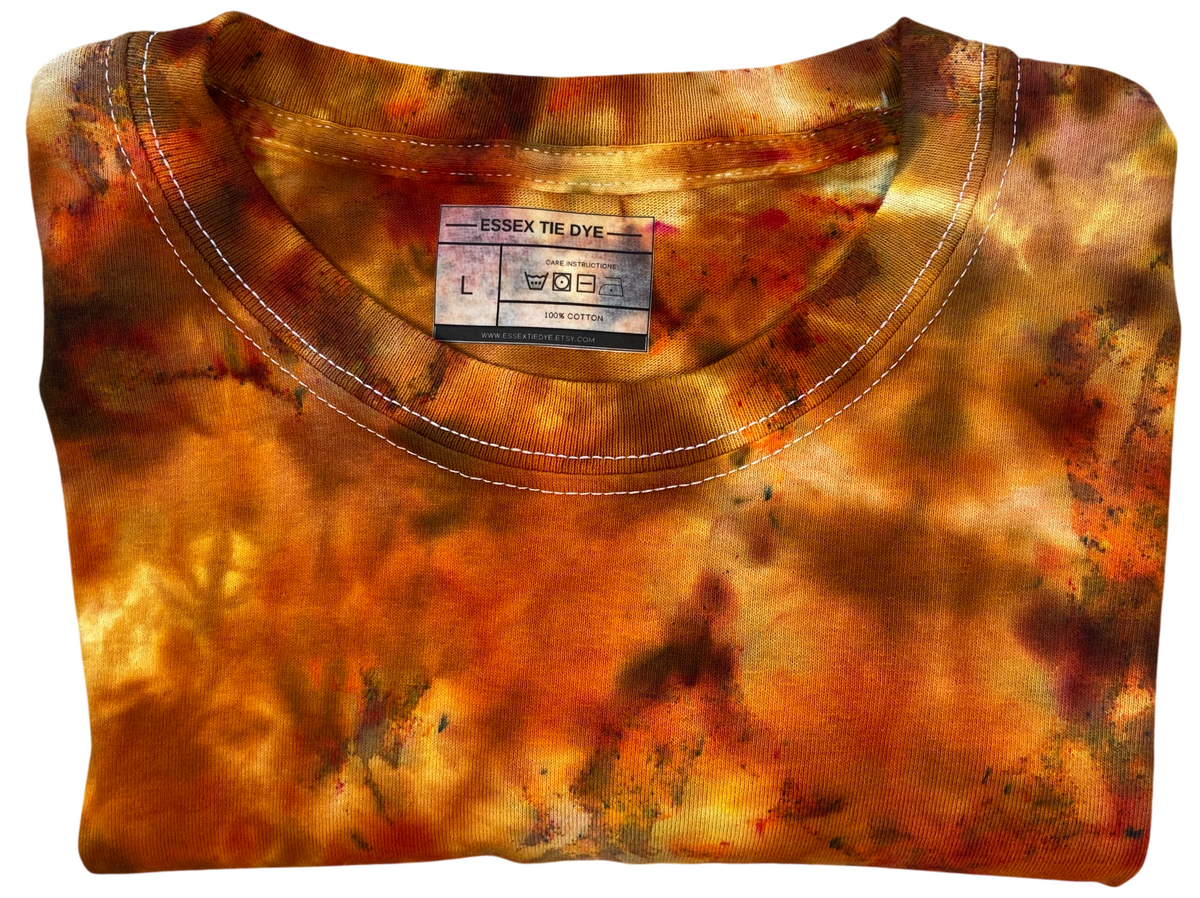 Folded view of the Firestone Ice Scrunch tie-dye sweatshirt featuring burnt orange, amber, golden yellow and deep brown patterns.