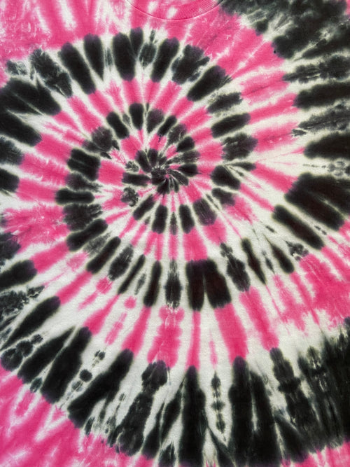 A close-up of a tie-dye spiral pattern featuring vibrant hot pink, black, and white dye streaks radiating from the center.