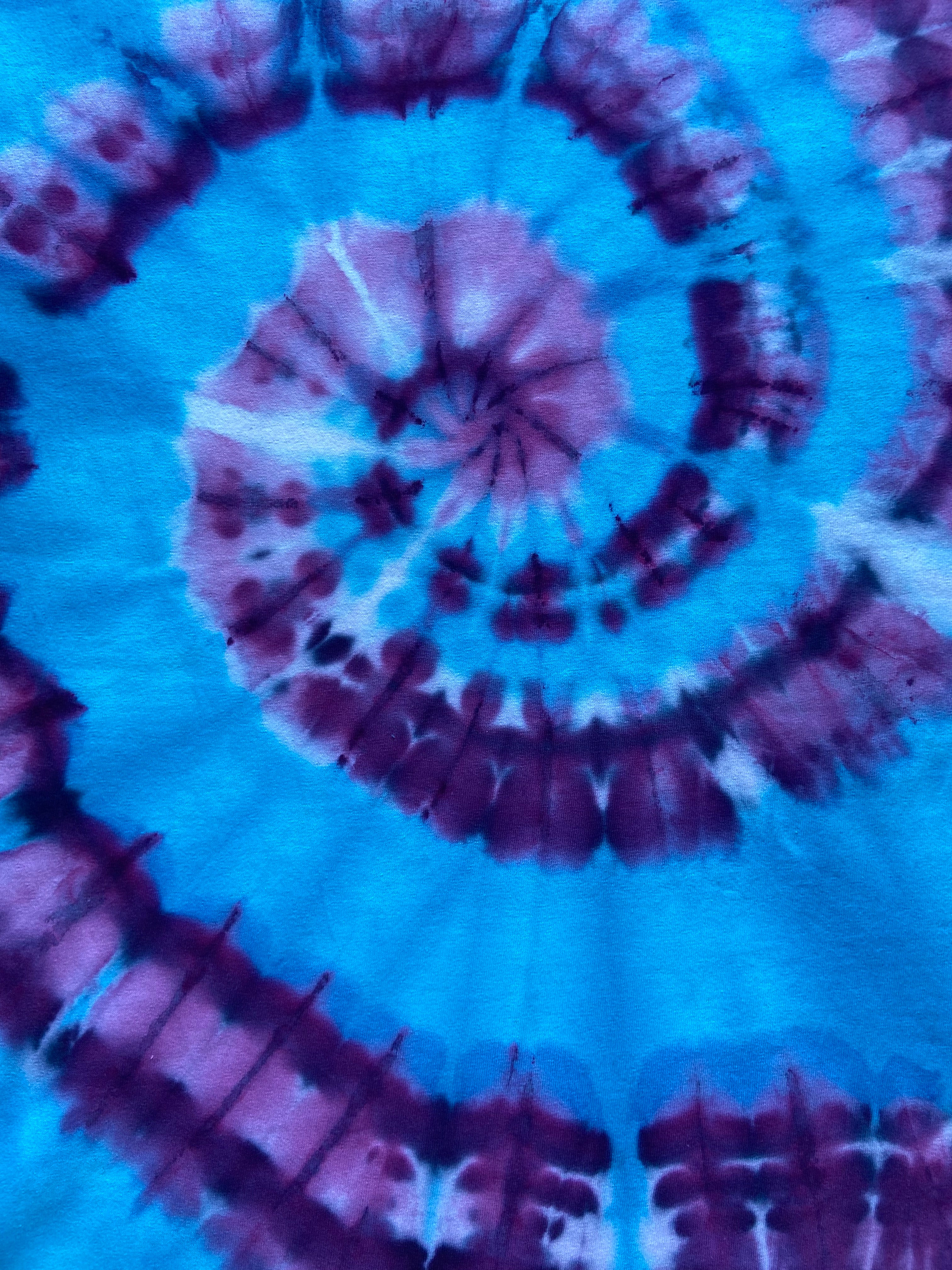 Close-up of a tie-dye pattern with concentric circles in blue and purple.
