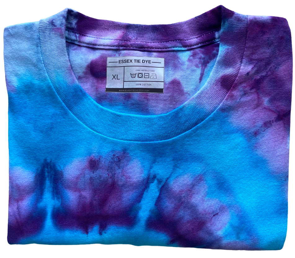 Folded tie-dye shirt with a visible label on a white background