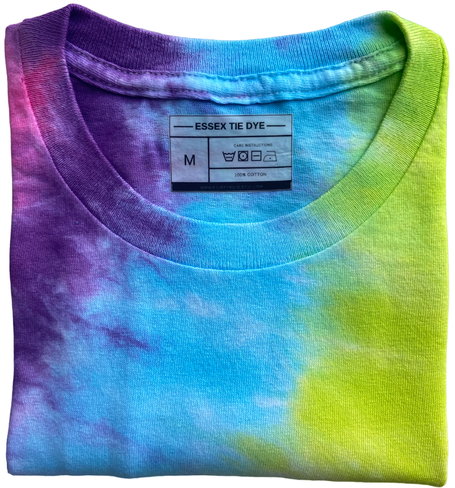 A folded short-sleeve cotton t-shirt featuring a vibrant multicolor tie-dye pattern with purple, blue, and neon yellow-green. The inside collar shows the 'ESSEX TIE DYE' brand label.