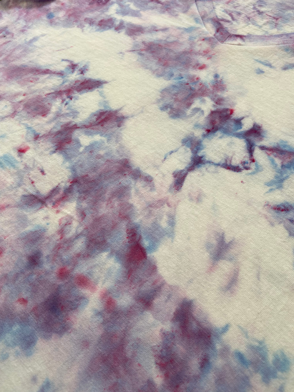 Abstract art with swirling patterns in red, blue, and white on a textured background