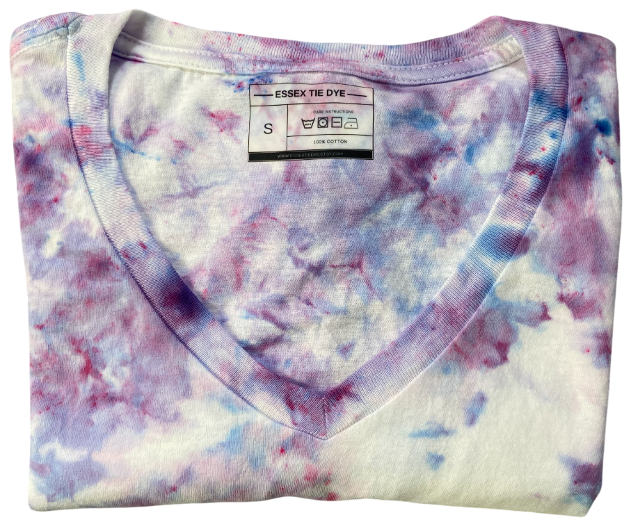 Folded tie-dye shirt with Essex Tie Dye label on a white background