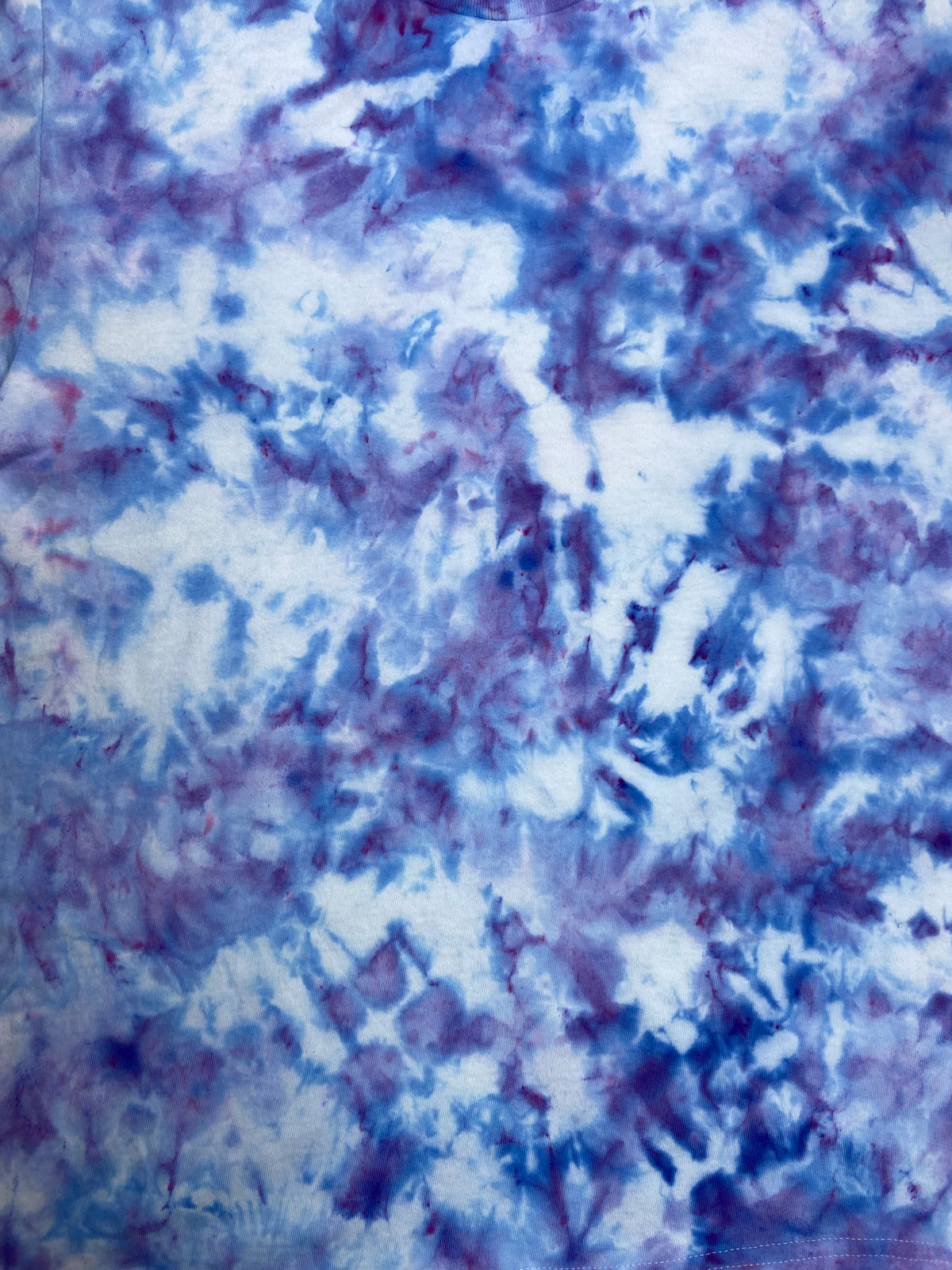 Close-up of Ice Blue Ice Scrunch tie-dye fabric featuring soft blue, lavender and white marbled patterns.