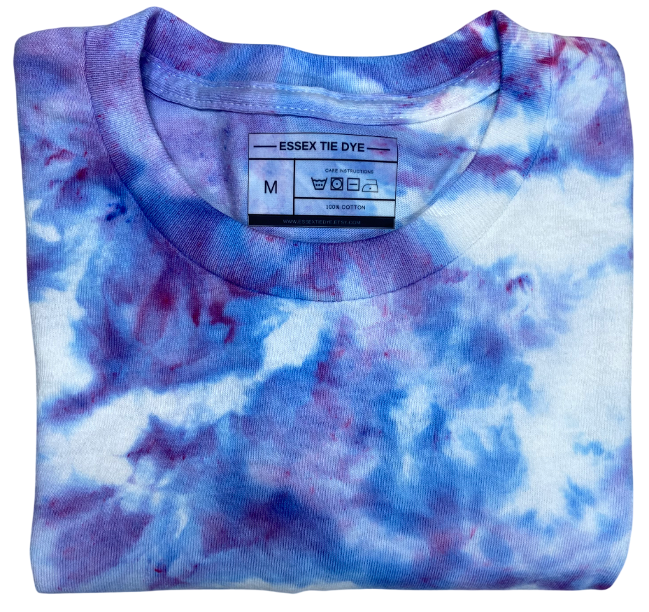 Folded tie-dye shirt with a visible label on a white background