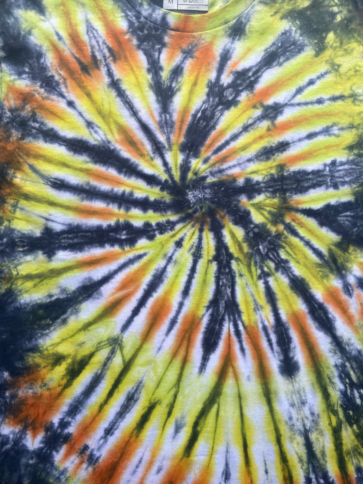 Close-up of the Sunset Vortex tie dye pattern showing black, yellow, orange and white hand dyed detail.