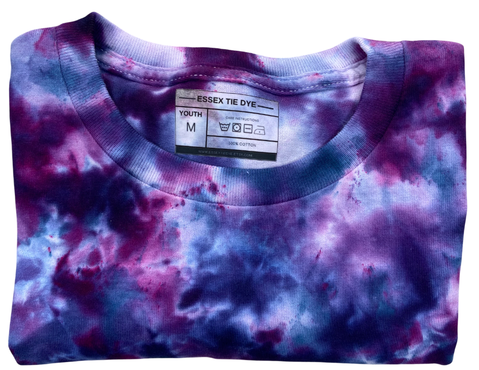 Folded tie-dye shirt with a visible label on a white background