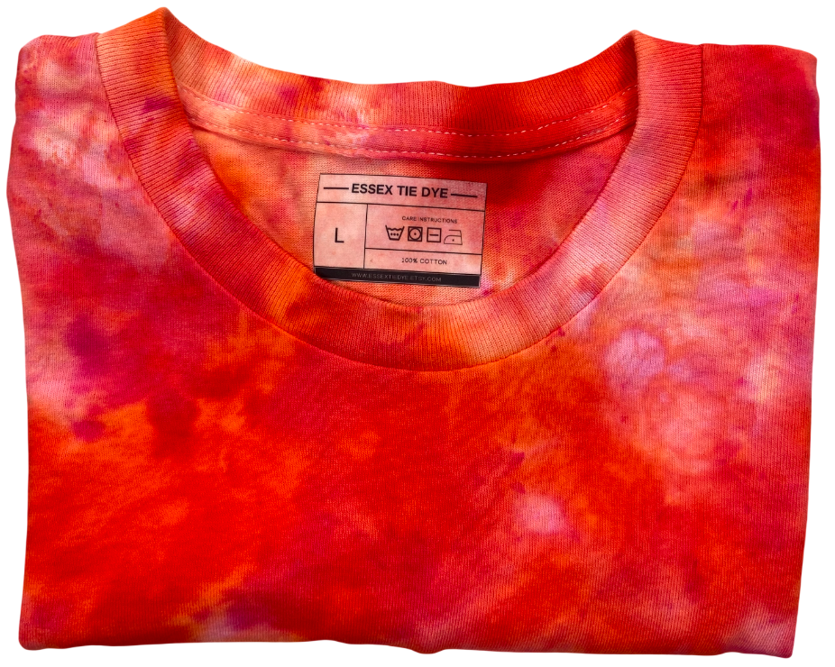 Close-up of the Deep Orange Ice Scrunch tie-dye T-shirt collar and label, showing deep orange, red and soft cream colour variations.