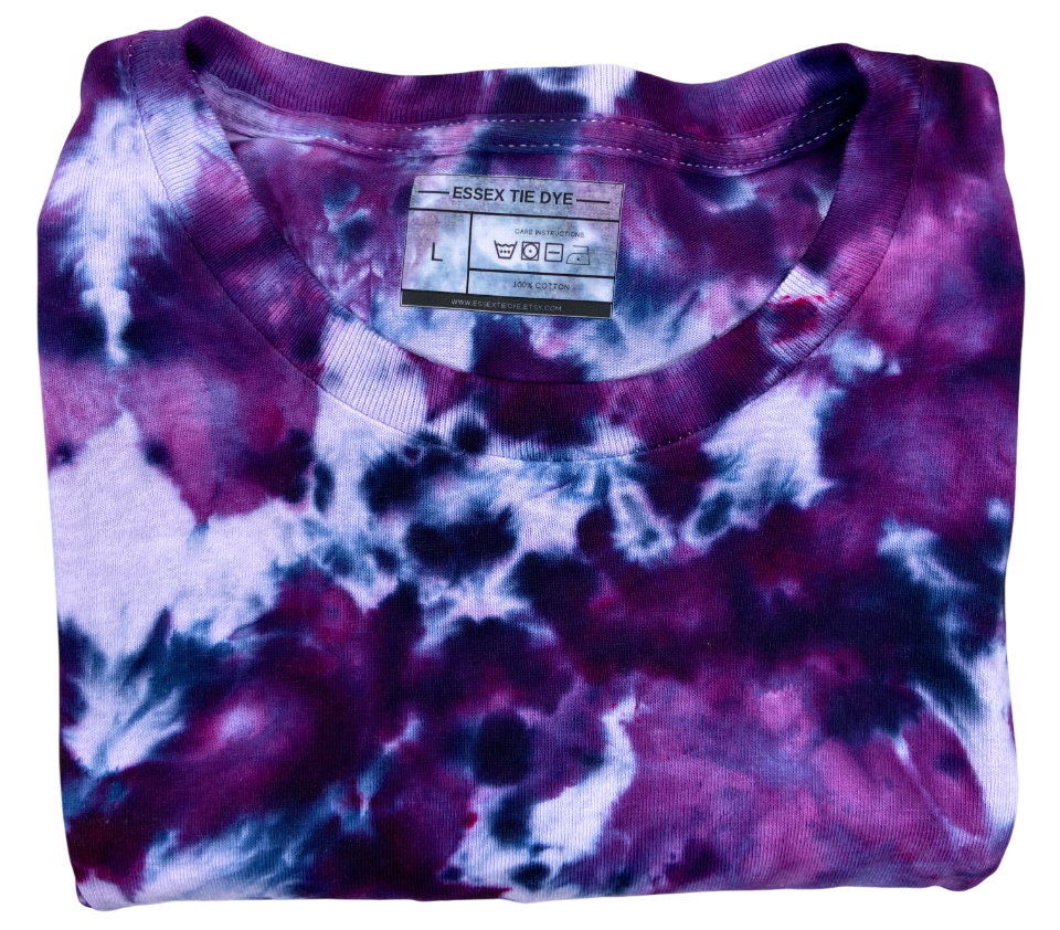 Folded tie-dye shirt with a visible brand label on a white background