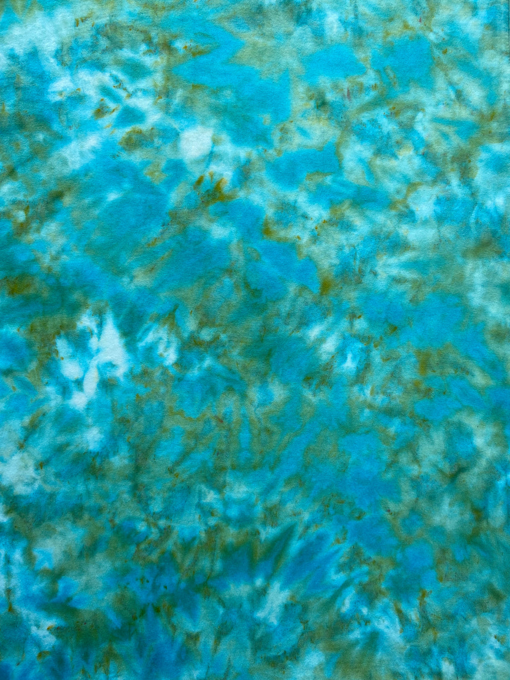Close-up of Cayman Isle Green tie-dye fabric showing aqua, turquoise, white and muted green colour variations.