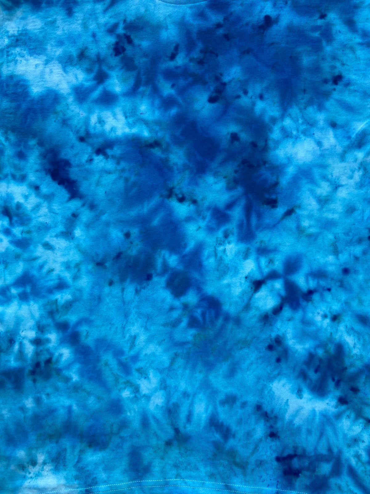 Close-up of Caribbean Blue Ice Scrunch tie-dye fabric featuring bright turquoise, aqua blue and deep navy-blue patterns, individually hand dyed in the UK.