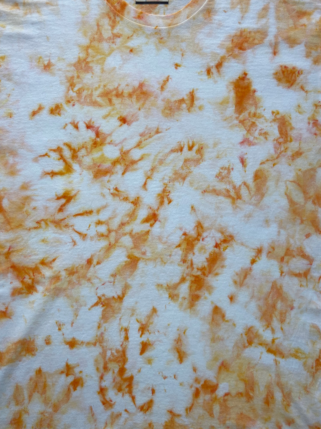 Close-up of Ivory Ice Scrunch tie-dye fabric featuring soft ivory, cream and warm golden-orange marbled patterns.