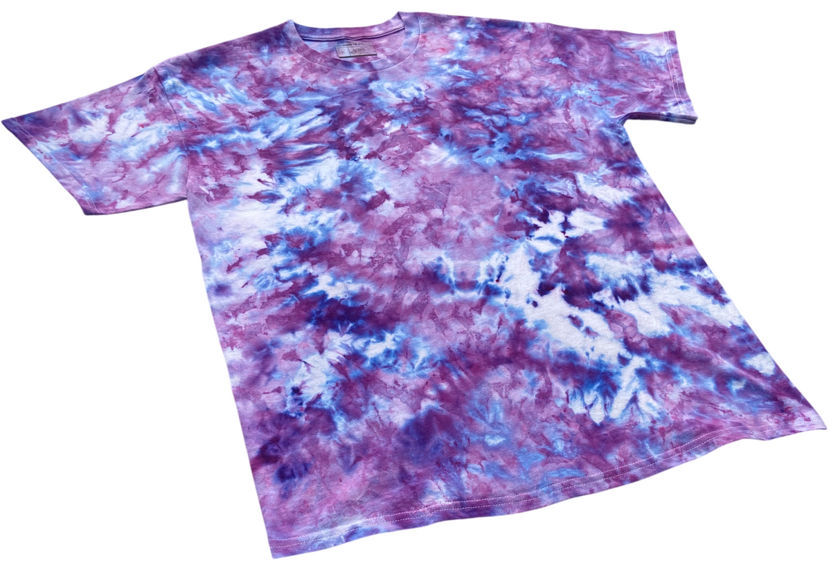 A short-sleeve crewneck t-shirt featuring a vibrant purple, blue, and white tie-dye pattern, displayed flat against a solid white background.