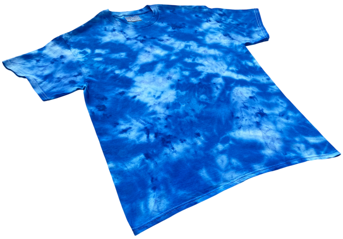Blue Bird Ice Scrunch tie-dye T-shirt shown at an angle, featuring vivid blue and white organic ice-dyed patterns.