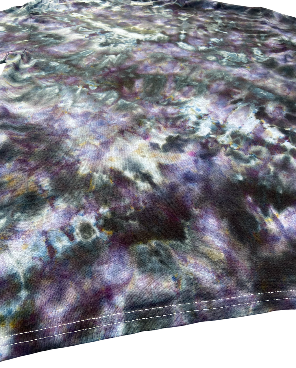 Close up of Tie-dye t-shirt with a multicolor pattern of greys and purples on white background