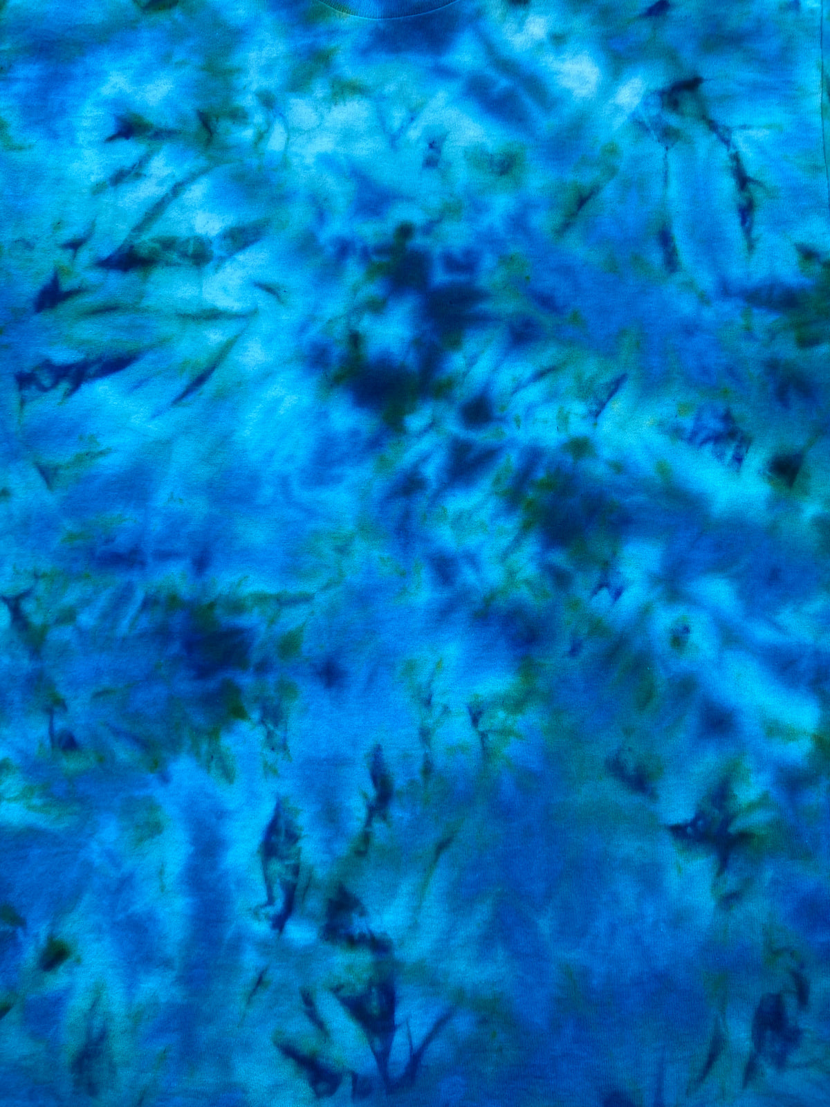 Close-up of Mermaid's Dream tie dye fabric showing swirling ocean blues, turquoise and subtle green marbled detailing.
