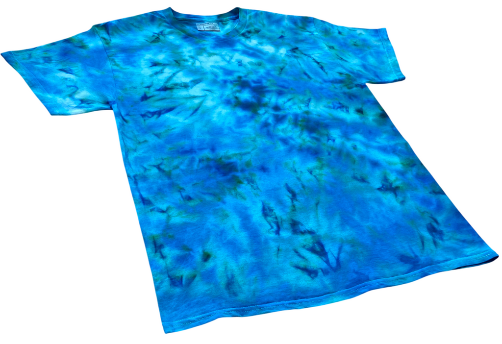 Mermaid's Dream tie dye T-shirt shown at an angle, featuring bright aqua, deep blue and green tones in a unique marbled design.