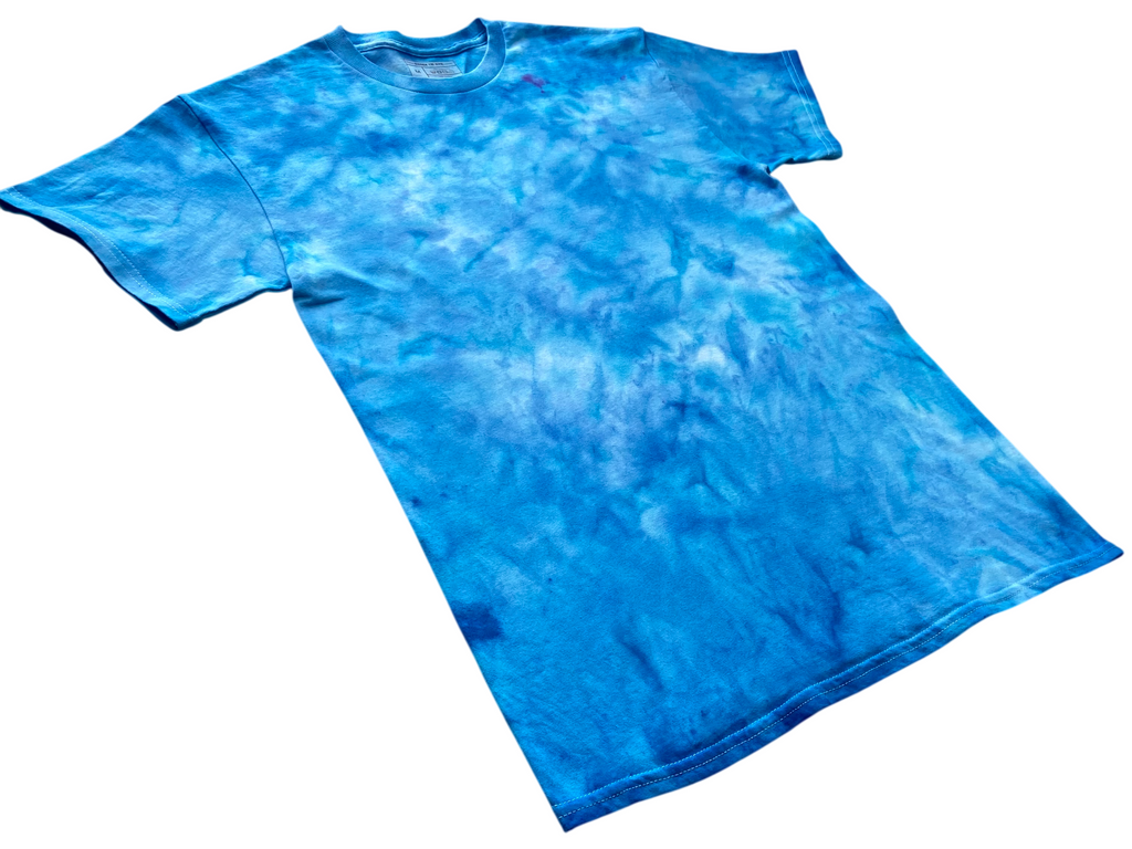 Alpine Blue Ice Scrunch tie dye T-shirt shown at an angle, featuring bright alpine blue, turquoise and white hand-dyed patterns.