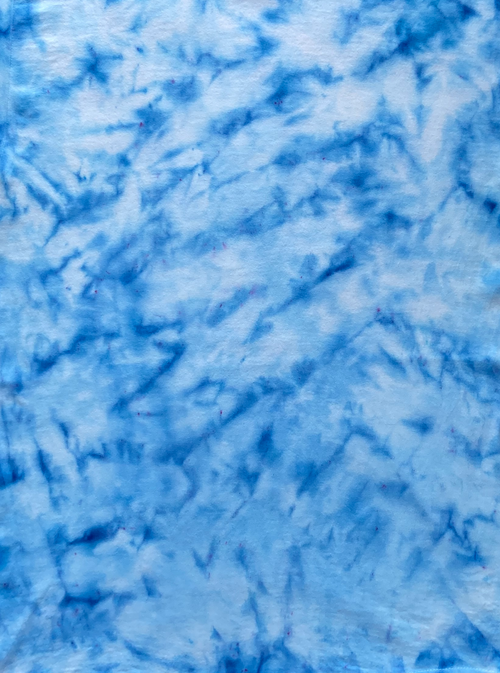 Close-up of Baby Blue Ice Scrunch tie-dye fabric featuring soft blue and white marbled patterns.