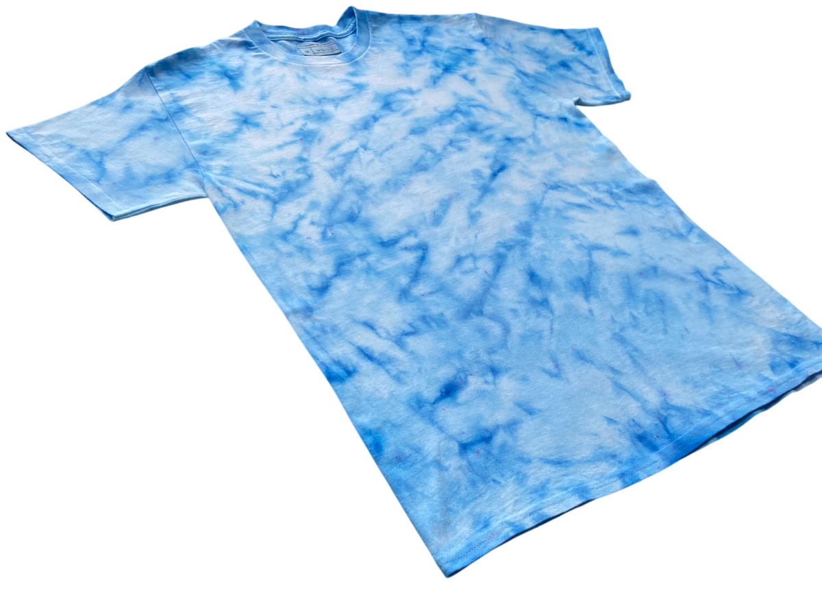 Baby Blue Ice Scrunch tie dye T-shirt shown at an angle, featuring soft sky blue and white hand-dyed patterns.