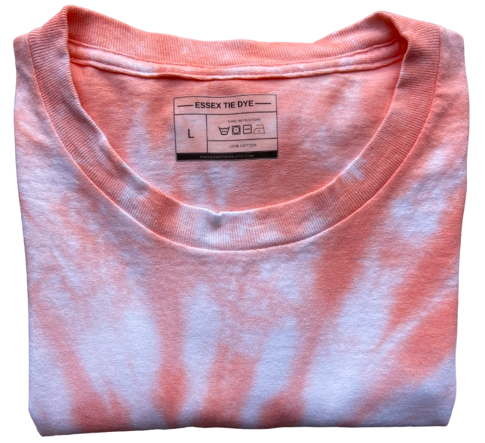 A folded short-sleeve crewneck t-shirt featuring a pink and white tie-dye pattern, with the brand label 'ESSEX TIE DYE' visible inside the collar.