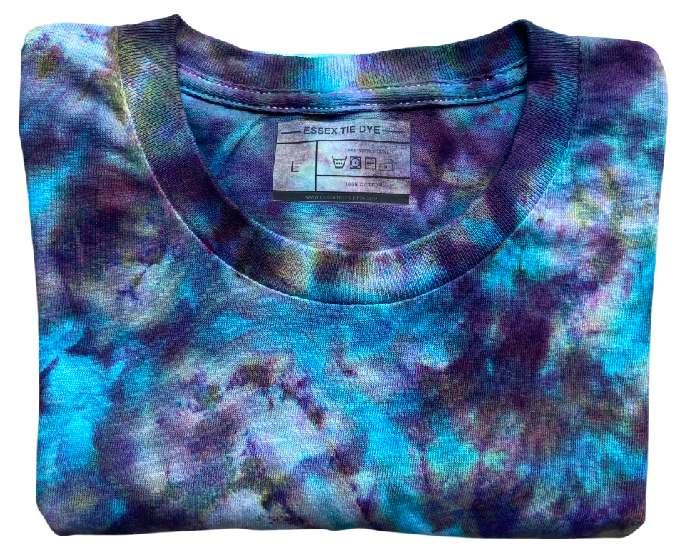 Folded The Alchemist Ice Scrunch tie dye T-shirt showing the crew neckline, Essex Tie Dye label and vibrant turquoise, purple and black marbled design.