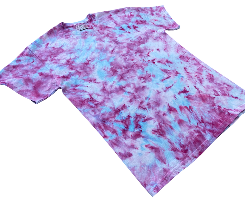 A short-sleeve crewneck t-shirt featuring a tie-dye pattern in purple and light blue, laid flat on a white background.