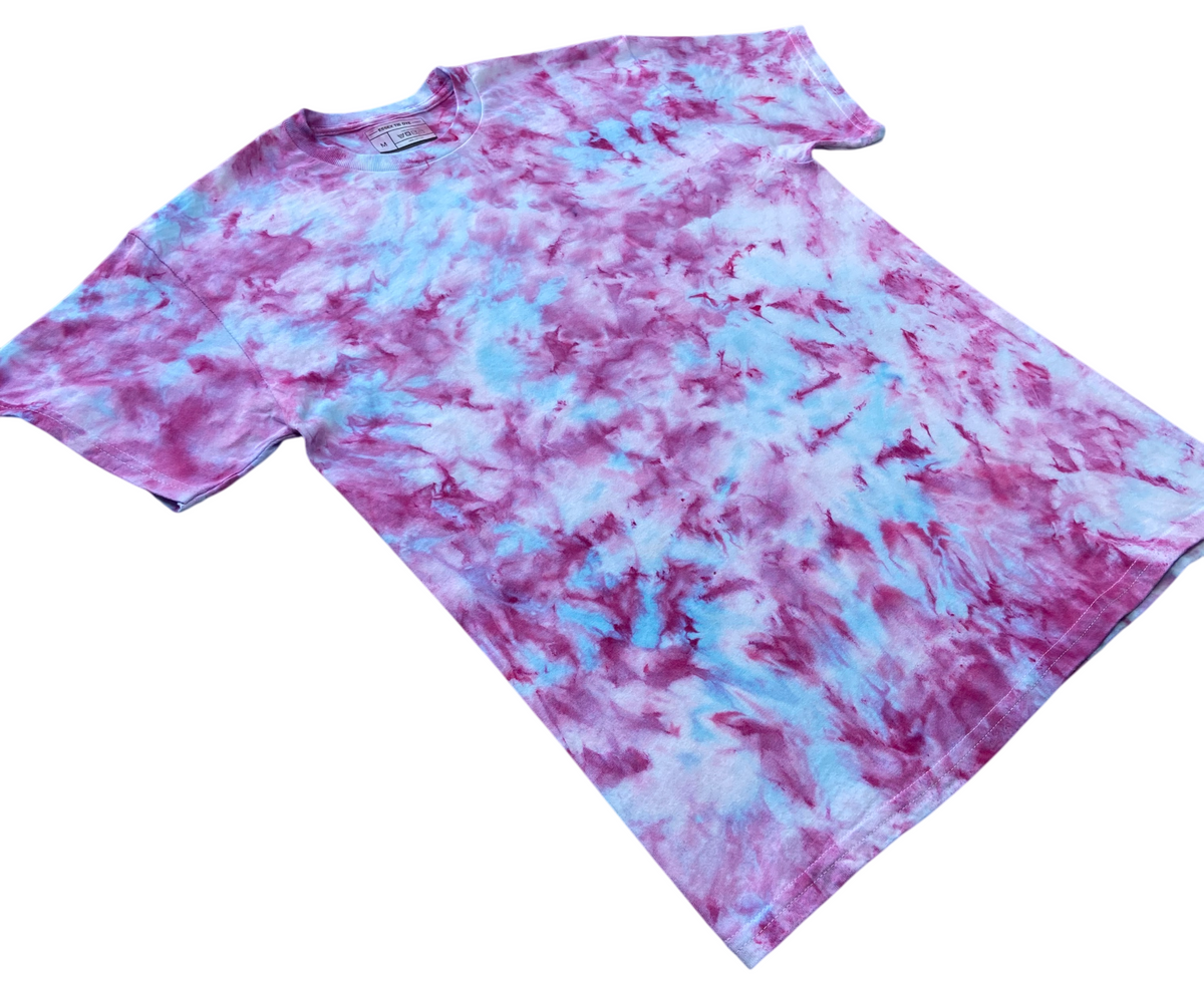 A short-sleeve crewneck t-shirt featuring a tie-dye pattern in purple and light blue, laid flat on a white background.