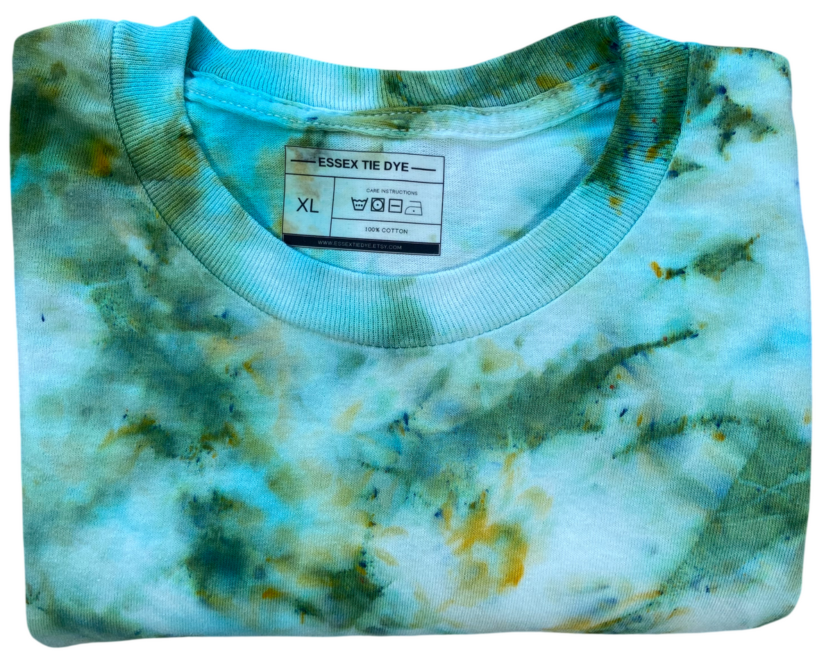 Folded Sea Glass Ice Scrunch long sleeve tie dye T-shirt showing the Essex Tie Dye neckline label and soft ocean-inspired colours.