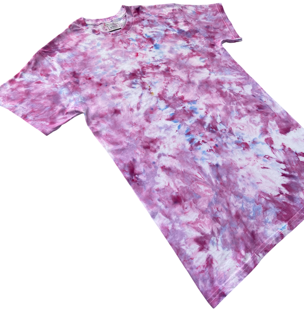 A short-sleeve crewneck tie-dye t-shirt featuring a marbled pattern of pink, purple, and light blue, laid flat against a solid white background.