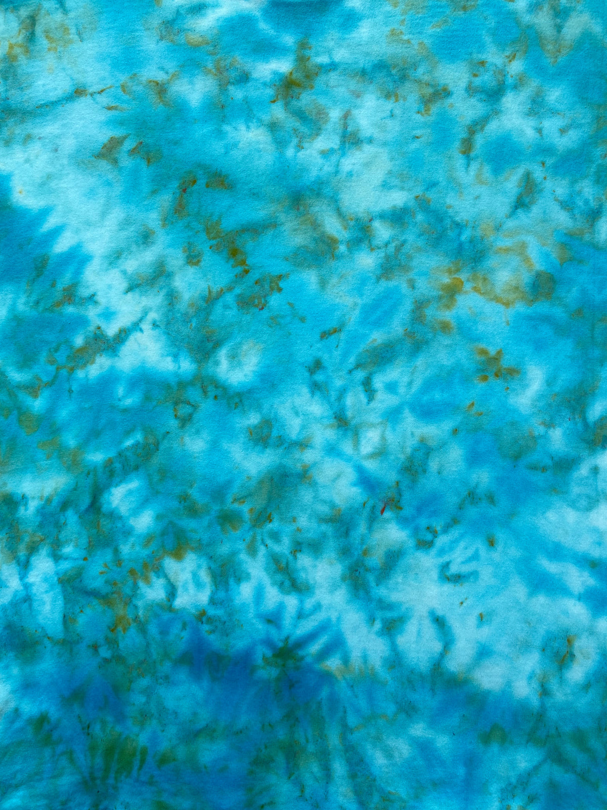 Close-up of Parakeet Ice Scrunch tie-dye fabric featuring turquoise, aqua, white and soft green colour variations.